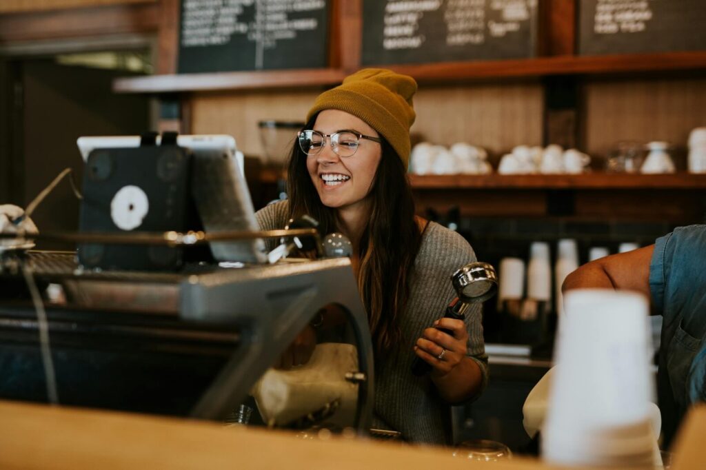Friendly café barista preparing coffee